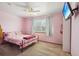 Bright bedroom with pink walls, a metal bed frame, and a wall-mounted TV at 11416 E 114Th Ave, Commerce City, CO 80640