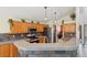 Open kitchen with granite countertops, island seating, stainless steel appliances, and wooden cabinets at 11416 E 114Th Ave, Commerce City, CO 80640