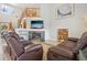 Bright living room with a fireplace, a large television, and comfortable leather seating at 11416 E 114Th Ave, Commerce City, CO 80640