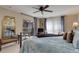 Bedroom with a metal bed frame, plush blue comforter, bench, and balcony access at 9546 Firenze Way, Highlands Ranch, CO 80126