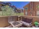 Outdoor patio with cozy seating and a fire pit, with community buildings and landscaping in the background at 9546 Firenze Way, Highlands Ranch, CO 80126