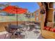 Outdoor patio with comfortable seating under an umbrella, overlooking beautifully landscaped grounds at 9546 Firenze Way, Highlands Ranch, CO 80126