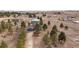 Aerial view featuring a blue house with a garage and surrounding trees in a rural setting at 6200 Bow Meadows Dr, Elizabeth, CO 80107