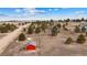 Expansive aerial view showcasing the property with mature trees and a distinct red outbuilding at 6200 Bow Meadows Dr, Elizabeth, CO 80107