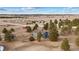 Broad aerial view showcasing the house with trees in a rural setting, plus a small red outbuilding at 6200 Bow Meadows Dr, Elizabeth, CO 80107