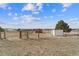 Spacious, fenced backyard area featuring a shed and small red outbuilding with a picturesque rural setting at 6200 Bow Meadows Dr, Elizabeth, CO 80107