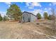 Backyard with a well built patio, landscaping beds and plenty of mature trees at 6200 Bow Meadows Dr, Elizabeth, CO 80107