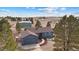 Aerial view of house featuring beautiful landscaping, an over sized garage, and cozy red front door at 6200 Bow Meadows Dr, Elizabeth, CO 80107