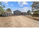 Residential home with a detached garage and gravel driveway is surrounded by mature trees at 6200 Bow Meadows Dr, Elizabeth, CO 80107