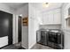 The laundry room features modern machines, wall-mounted cabinets, and stylish decor, and lots of natural light at 6200 Bow Meadows Dr, Elizabeth, CO 80107