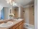 Bright bathroom featuring a double sink vanity, large mirror, and a glass-enclosed walk-in shower at 5115 S Valdai St, Aurora, CO 80015