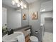 Neutral bathroom featuring a single sink vanity, decorative wall art, and a combined toilet and laundry area at 5115 S Valdai St, Aurora, CO 80015