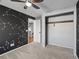 Bedroom with constellation accent wall, ceiling fan, closet, and neutral gray carpet at 5115 S Valdai St, Aurora, CO 80015