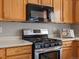 Kitchen featuring stainless steel stove with range hood, light countertops, and warm wood cabinets at 5115 S Valdai St, Aurora, CO 80015