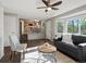 Sunlit living room showcasing hardwood floors, modern furnishings, and a seamless transition to the kitchen at 5115 S Valdai St, Aurora, CO 80015