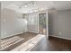 A spacious room with wooden floors, natural light, and an open door to the outside at 5115 S Valdai St, Aurora, CO 80015