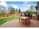 Large deck with a dining table, chairs, and a landscaped yard with a privacy fence at 705 Prairie Ridge Rd, Highlands Ranch, CO 80126