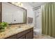 Bathroom featuring a granite countertop, undermount sink, and shower-tub combo at 705 Prairie Ridge Rd, Highlands Ranch, CO 80126