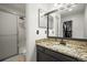 Bathroom featuring a granite countertop, undermount sink, and tiled shower with glass door at 705 Prairie Ridge Rd, Highlands Ranch, CO 80126