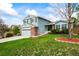 Two-story home with blue siding, a brick garage, green lawn, and decorative landscaping at 705 Prairie Ridge Rd, Highlands Ranch, CO 80126