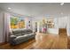Bright living room with wood floors, large windows, and a view of the kitchen at 705 Prairie Ridge Rd, Highlands Ranch, CO 80126