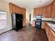 Well-lit kitchen featuring oak cabinetry, granite countertops, and modern black appliances at 7811 St Vrain Dr # 68, Frederick, CO 80530