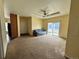Bright living room with carpeted floors, tray ceiling with fan, and sliding glass door at 7811 St Vrain Dr # 68, Frederick, CO 80530