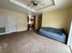 Bright living room with carpeted floors, tray ceiling with fan, and views to kitchen at 7811 St Vrain Dr # 68, Frederick, CO 80530
