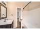 Bright bathroom featuring a modern vanity with sink, shower/tub, and view to additional room at 9661 Autumnwood Pl, Highlands Ranch, CO 80129