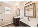 Bright bathroom featuring dual modern vanities with sinks, mirrors, and dark wood cabinets at 9661 Autumnwood Pl, Highlands Ranch, CO 80129