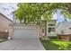 Charming two-story home with a well-manicured lawn, large window, and attached two-car garage at 9661 Autumnwood Pl, Highlands Ranch, CO 80129