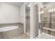Bright bathroom with a tub, glass-door shower, and walk-in closet entrance at 540 E Fremont Pl, Centennial, CO 80122