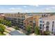 Aerial view of the building featuring balconies, brick facade, and mature trees at 7240 W Custer Ave # 303, Lakewood, CO 80226