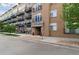 Exterior view of The Lofts building entrance and sidewalk, beautifully landscaped with rocks and greenery at 7240 W Custer Ave # 303, Lakewood, CO 80226