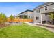 Expansive backyard featuring a stone fire pit, a plunge pool, a covered patio with an outdoor dining set and an expansive grassy area at 14423 Shasta Daisy Ln, Parker, CO 80134