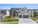 An exterior shot of a modern two-story home with a three-car garage, professional landscaping, and an inviting entrance at 14423 Shasta Daisy Ln, Parker, CO 80134