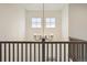 Bright foyer featuring a modern chandelier, second story windows and dark wood railing at 14423 Shasta Daisy Ln, Parker, CO 80134