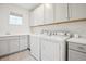 Well-organized laundry room with gray cabinets, sink, and modern washer and dryer at 14423 Shasta Daisy Ln, Parker, CO 80134