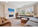 A cozy living room with a fireplace and comfortable seating area and large windows at 14423 Shasta Daisy Ln, Parker, CO 80134