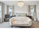 Primary bedroom with chandelier, neutral decor, large bed, and lots of natural light at 14423 Shasta Daisy Ln, Parker, CO 80134