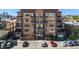 Attractive condo building featuring brick accents, balconies, reserved parking spaces, and mountain views at 1925 W 32Nd Ave # 404, Denver, CO 80211