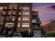 Exterior view of a condo building highlighting its balconies and windows against a colorful dusk sky at 1925 W 32Nd Ave # 404, Denver, CO 80211