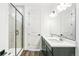 This bathroom showcases a double sink vanity, framed mirror, decorative lighting, and a glass-enclosed shower at 4323 Soapberry Pl, Castle Rock, CO 80108