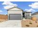 Charming home with gray garage door, stone accents, and manicured front yard at 4323 Soapberry Pl, Castle Rock, CO 80108