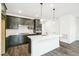 Bright kitchen featuring dark cabinets, stainless steel appliances, and a white quartz island with a sink at 4323 Soapberry Pl, Castle Rock, CO 80108