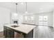 Open kitchen featuring an island with white quartz countertops, dark cabinets, and stainless steel appliances at 4323 Soapberry Pl, Castle Rock, CO 80108