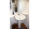 Compact powder room features a pedestal sink, a decorative mirror, and a wood floor at 2848 Merry Rest Way, Castle Rock, CO 80109