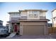 Two-story home features a tan-colored exterior, an attached garage, and a brick-paved driveway at 2848 Merry Rest Way, Castle Rock, CO 80109