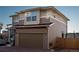 Two-story home featuring a tan-colored exterior, an attached garage, and a brick-paved driveway at 2848 Merry Rest Way, Castle Rock, CO 80109