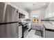 Bright white kitchen featuring stainless steel appliances and black and white tile at 1475 N Humboldt St # 20, Denver, CO 80218